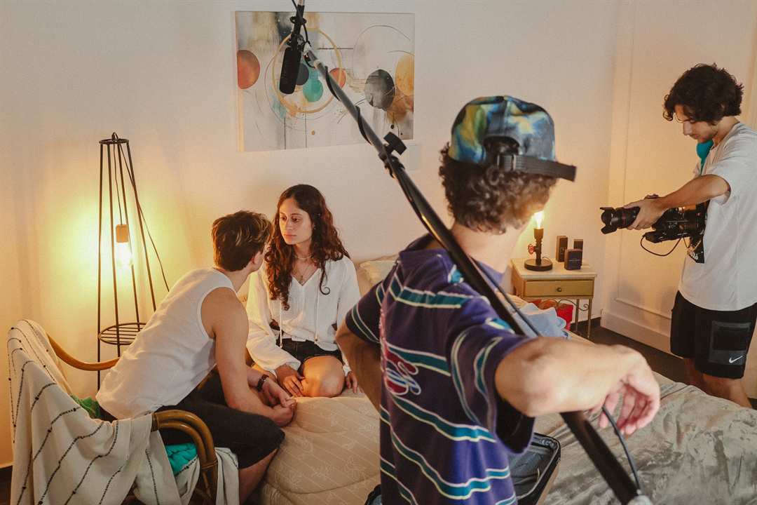 Set de quarto montado com equipe gravando