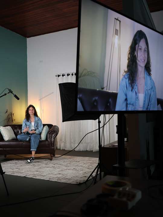 Atriz gravando sozinha em cenário montado